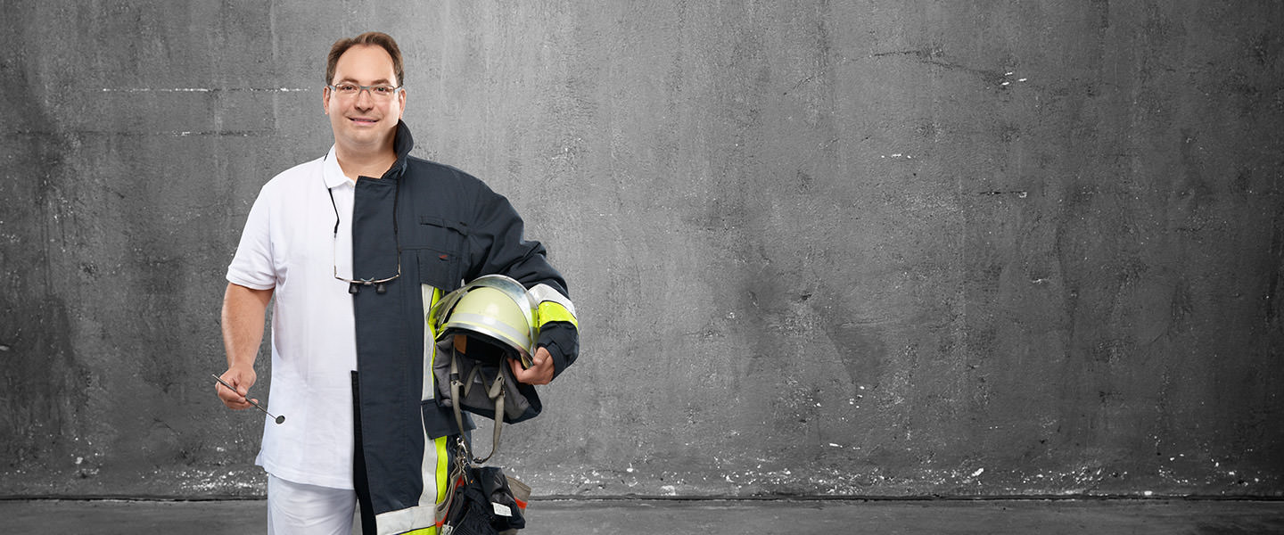 Fotomontage eines Mannes: Halb Zahnarzt in weißer Kleidung, halb Feuerwehrmann in Uniform.